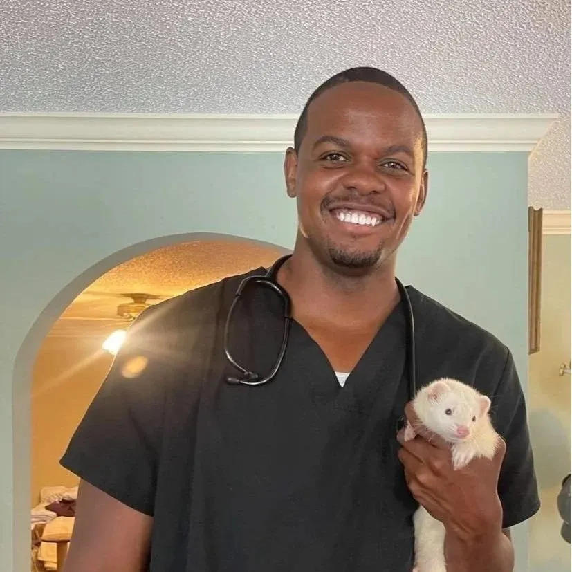 Dr. Kevin Scruggs smiling while holding a white ferret